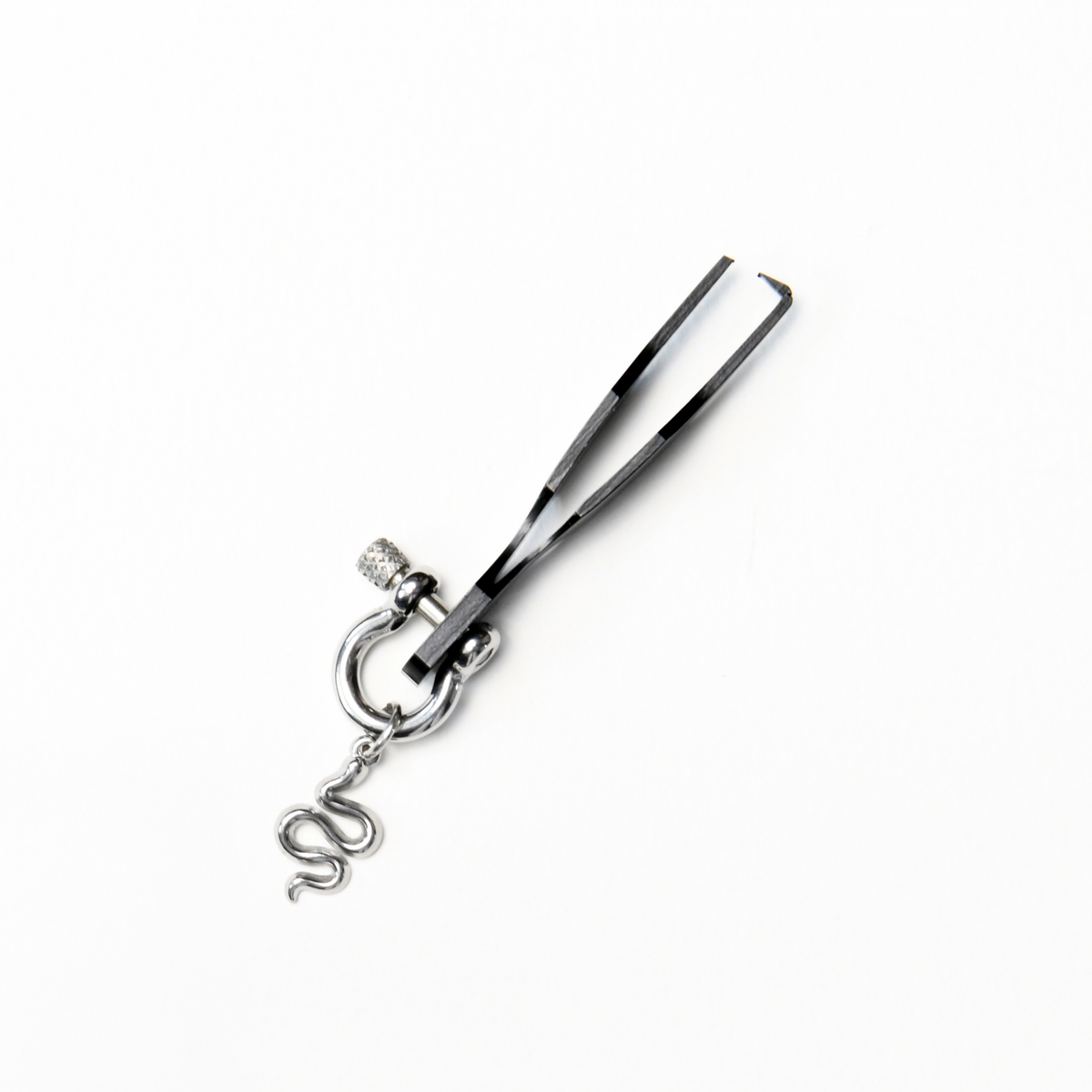 Black metal split ring opener with two narrow prongs designed to separate the coils of a split ring. A silver coloured horseshoe-shaped screw clasp and small snake charm hang from the handle.
