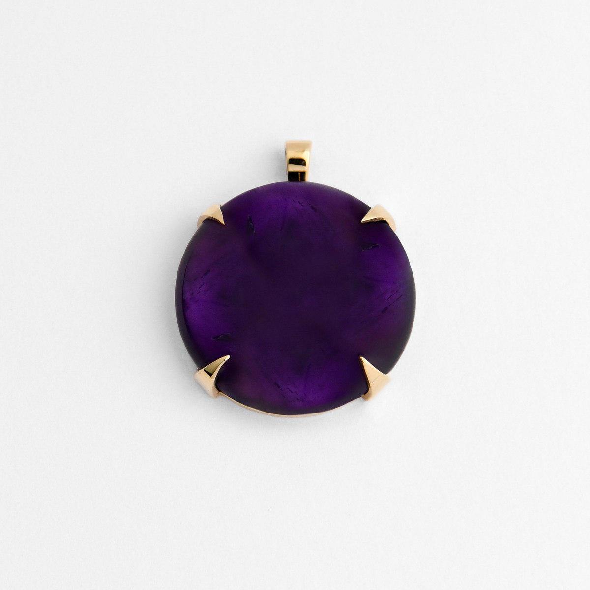 Spar, a round pendant in warm, golden-yellow brass, with four triangular claws holding rich purple amethyst, ranging from deep violet to brighter translucent purple. As a natural stone, each piece varies.