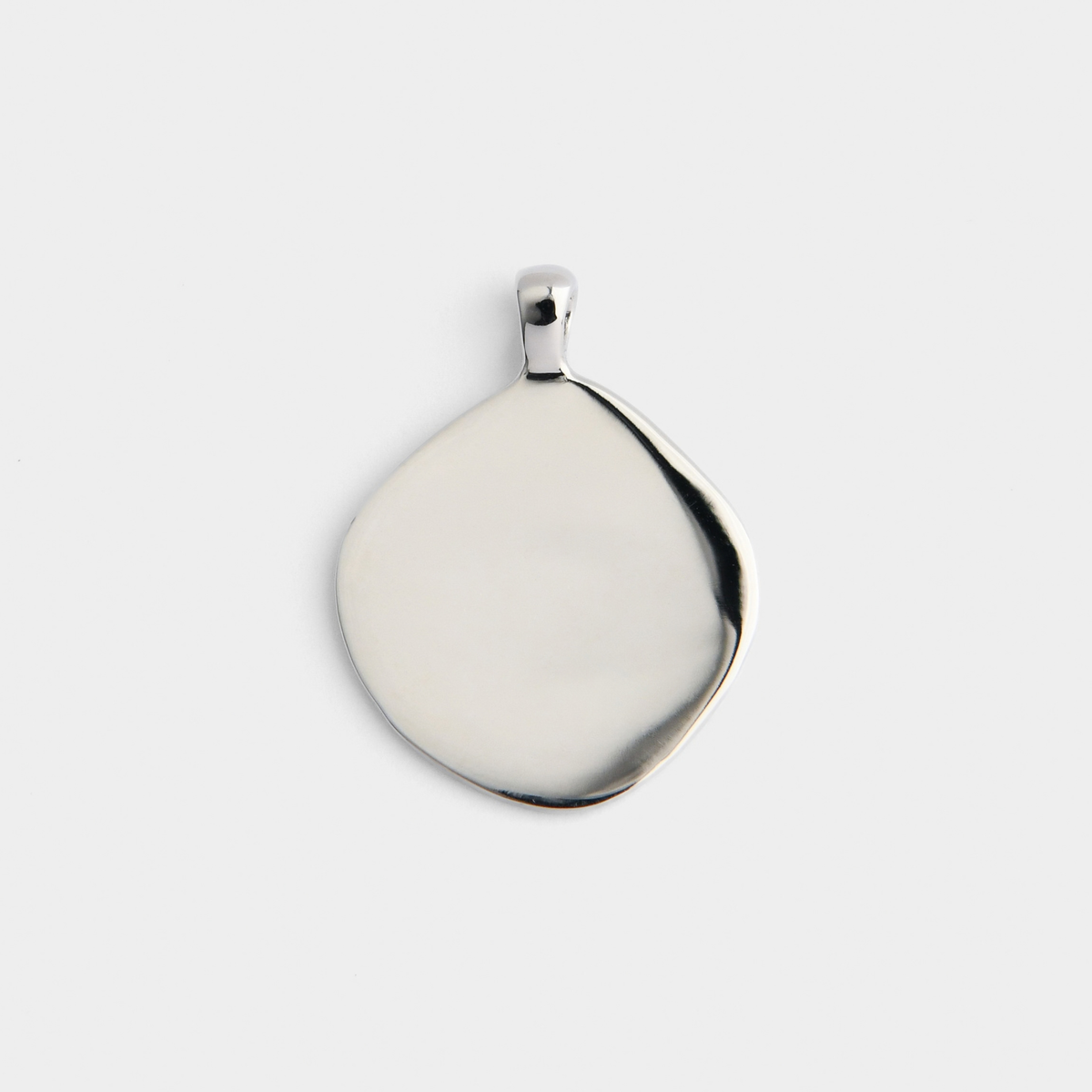 Back of Vea in cool, silvery white bronze, still irregularly shaped and showing its smooth, plain reverse for pesonalised engraving