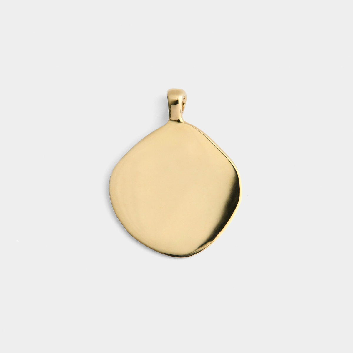 Back of Vea in warm, golden-yellow brass, still irregularly shaped and showing its smooth, plain reverse for pesonalised engraving