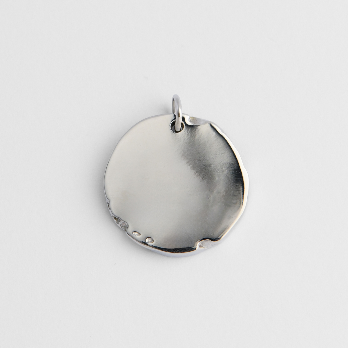 Back of Bolide in cool, silvery white bronze, showing its smooth, plain reverse for personalised engraving.