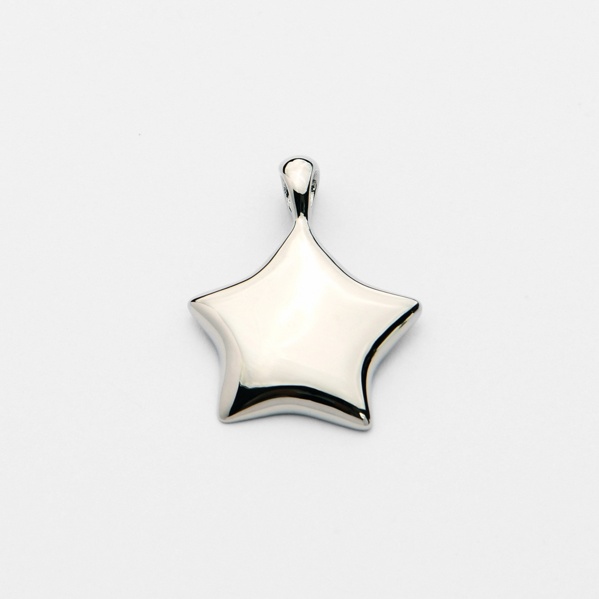 Lyre, a smooth five-pointed star pendant in cool, silvery white bronze, with softly rounded, slightly curved points and a gently domed surface.