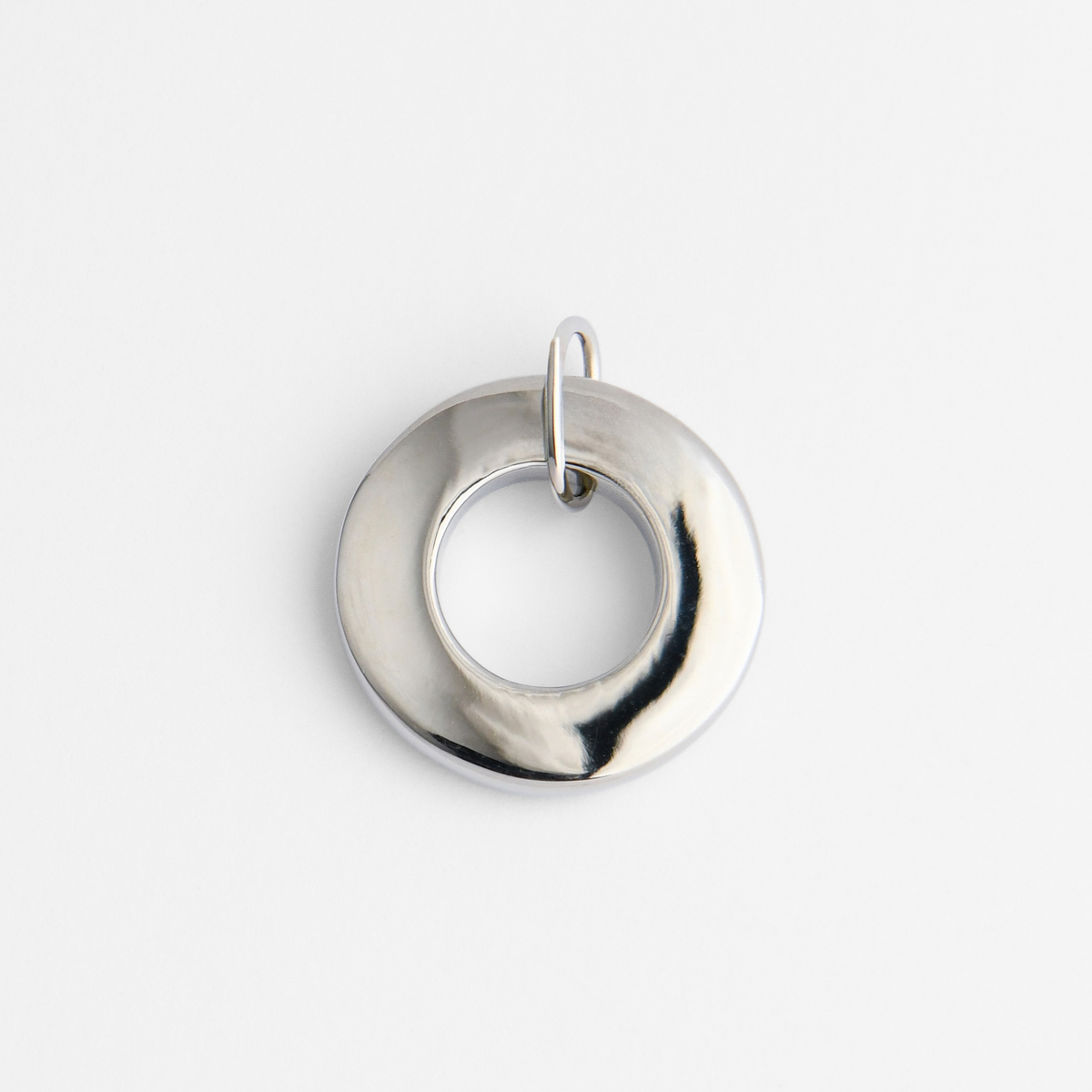 Back of Dromi, a rounded ring pendant in cool, silvery white bronze, showing its smooth, flat reverse for personalised engraving.