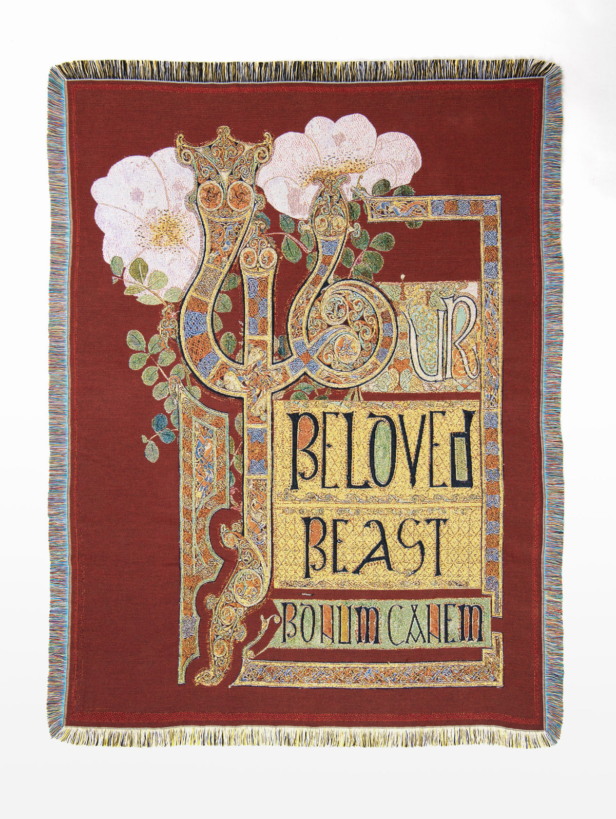 Beloved Beast woven throw in rich oxblood red, with two ornate, elongated serpent-like beasts intertwined among large pale pink flowers and green foliage. One serpent forms the beginning of the letter Y in the words “YOUR BELOVED BEAST”, surrounded by intricate gold, blue and rust ornamentation, with the Latin motto “PRO AMORE FERARUM” below.
