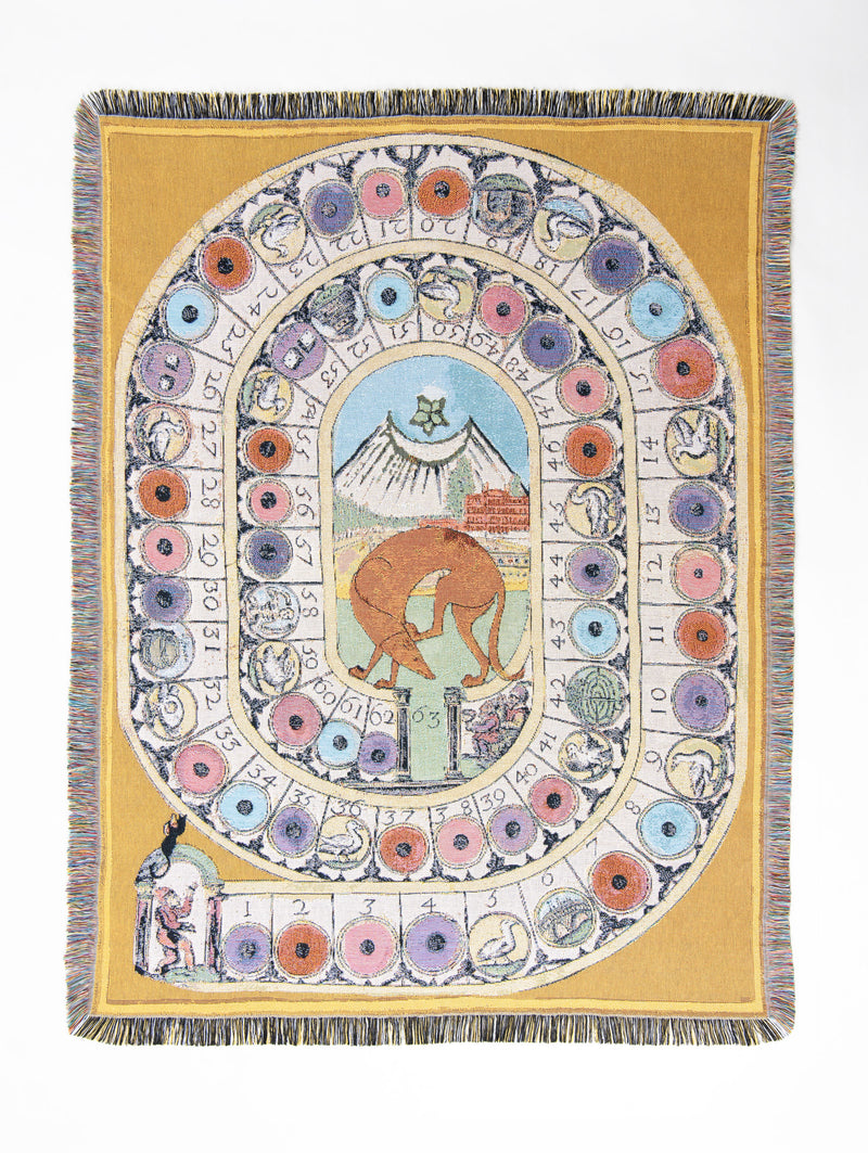 Wayward & Wandering woven throw in warm mustard yellow, designed as a winding, numbered game board filled with colourful pink, blue, lilac and orange spaces and tiny illustrated creatures. At its centre, a rust-coloured hound wanders beneath a crescent moon, while a tiny Cupid secretly tends the garden in the landscape behind him.