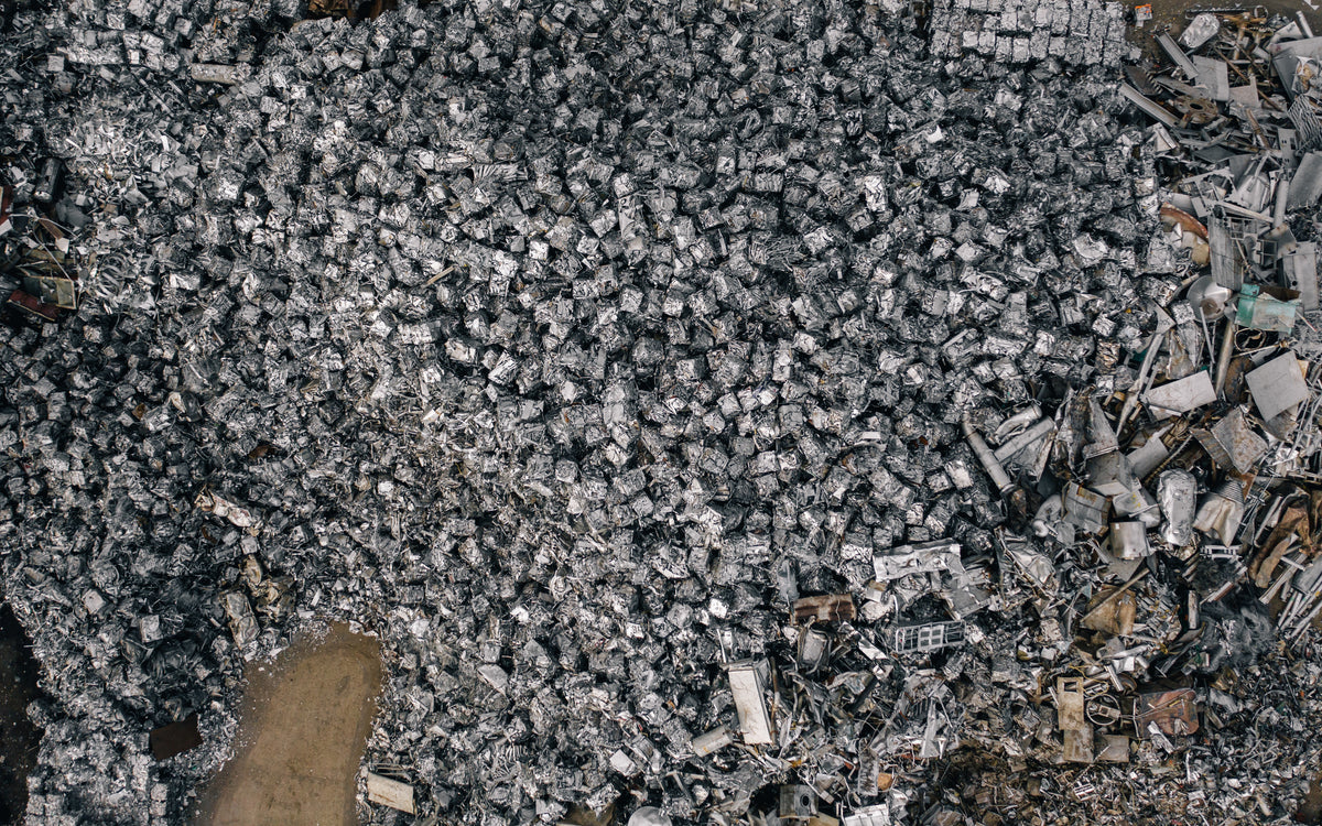An aerial view of mountains of crushed metal, their twisted silver-grey fragments forming an almost rocky landscape.